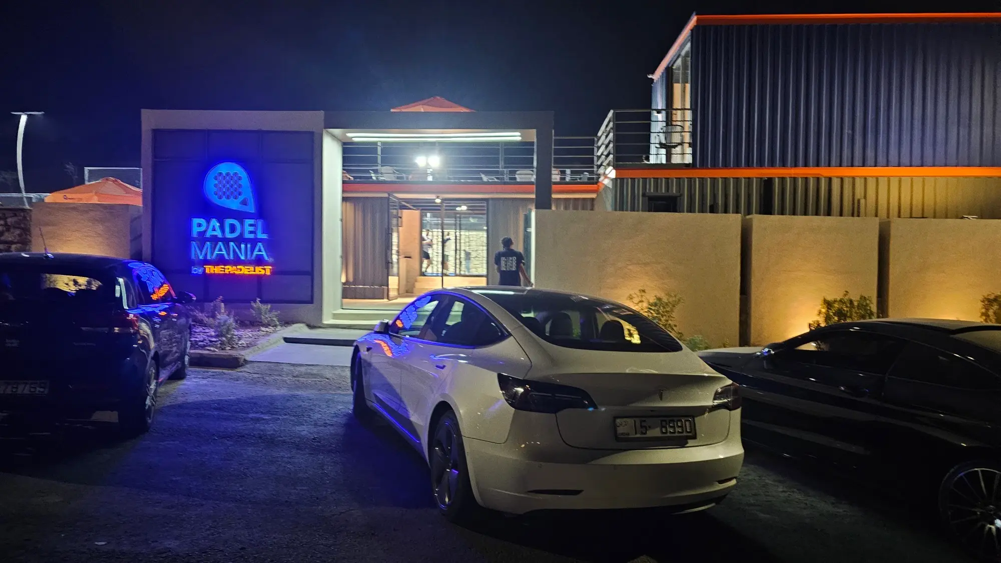The Padel Mania entrance at night, with the club's illuminated sign