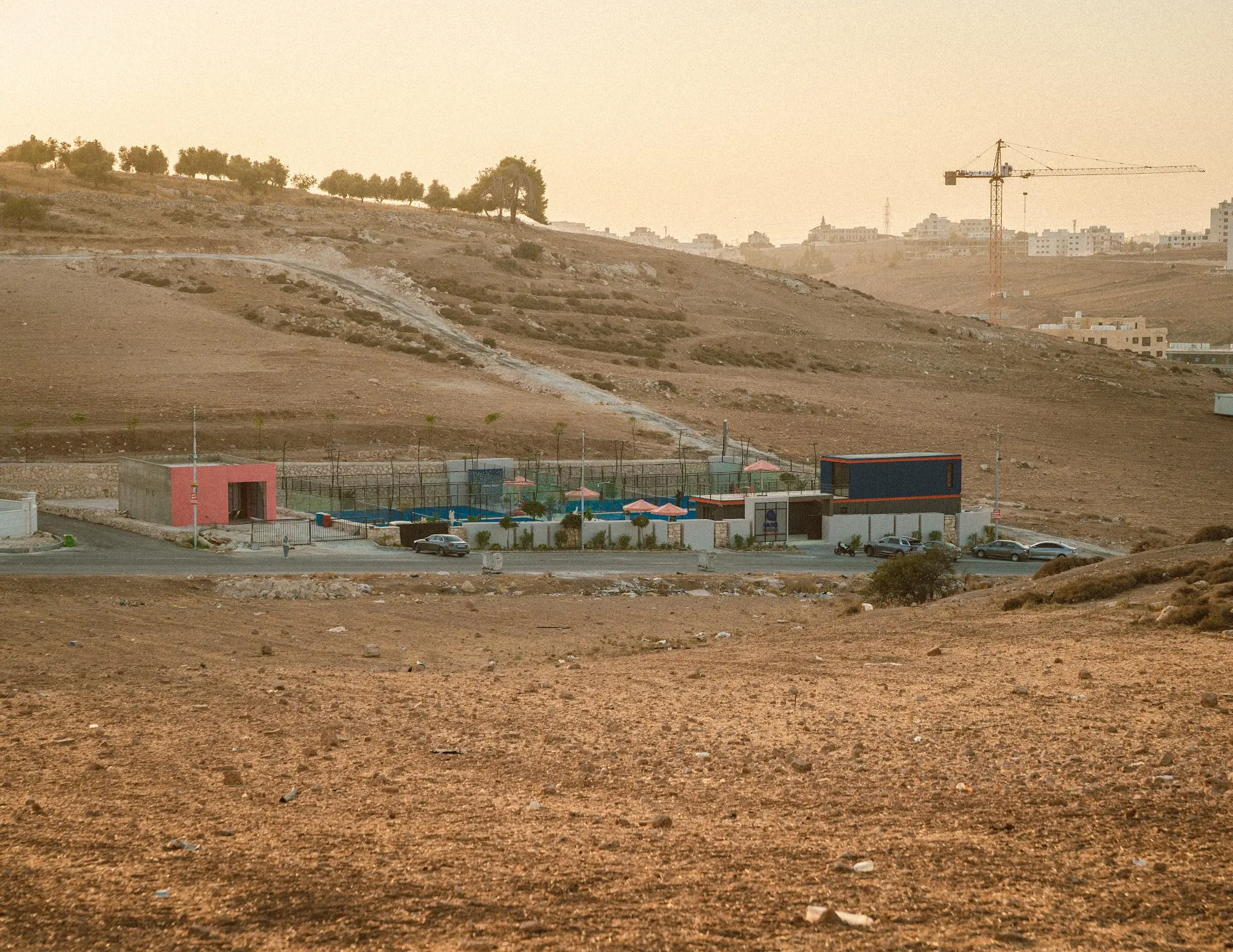 Padel Mania's courts seen across the hills of the Abdoun Corridor at dusk